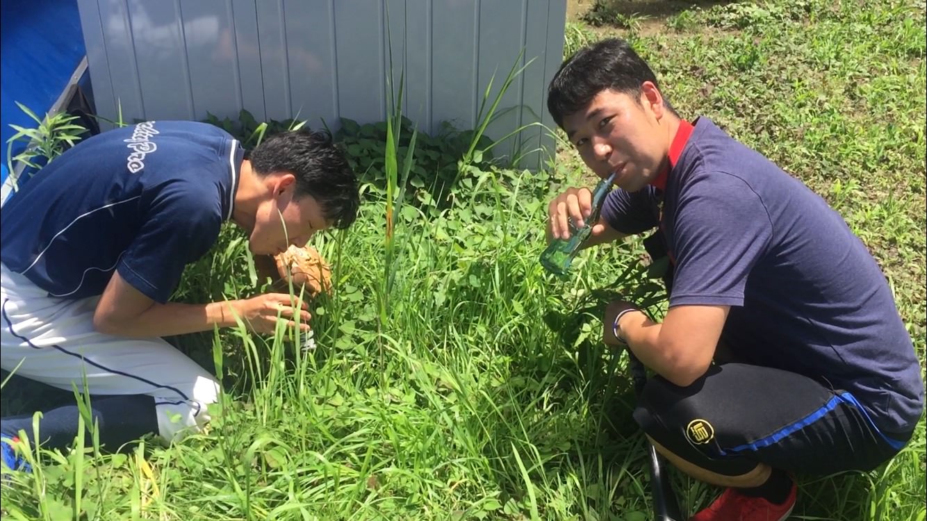 元祖野球YouTuber向が草むらでコーラ瓶にストローを刺して吸っている画像